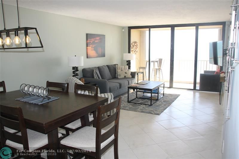 a living room with furniture and a floor to ceiling window