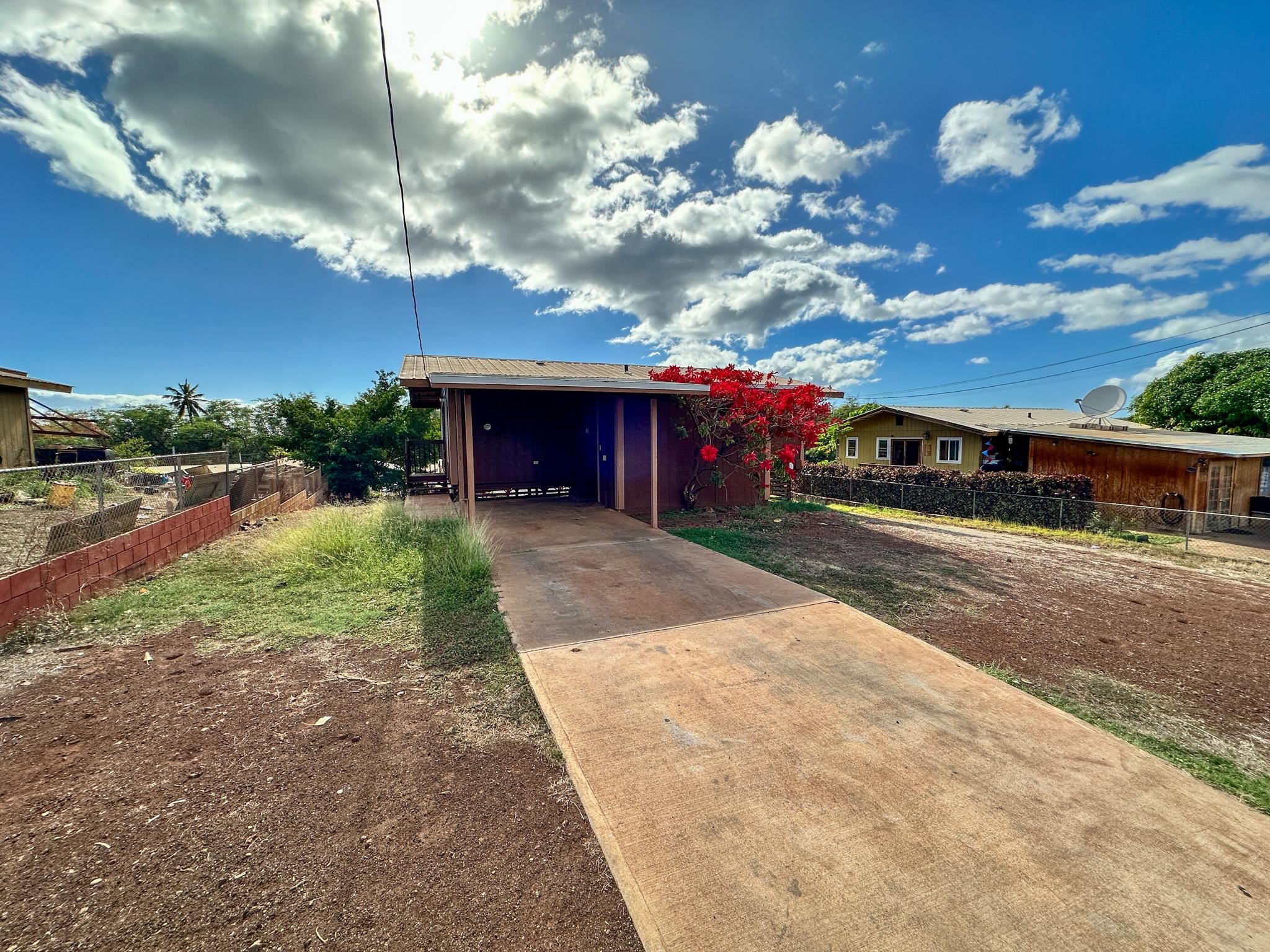 a view of a house with a yard and potted plants