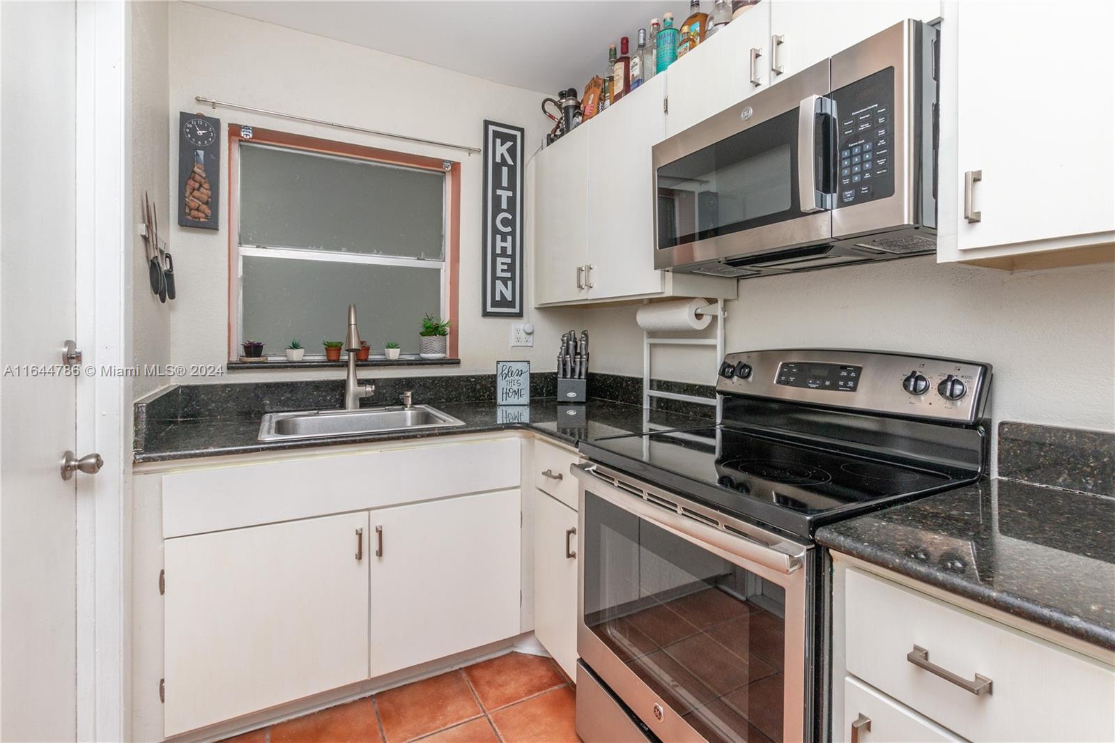 a kitchen with cabinets stainless steel appliances and a sink