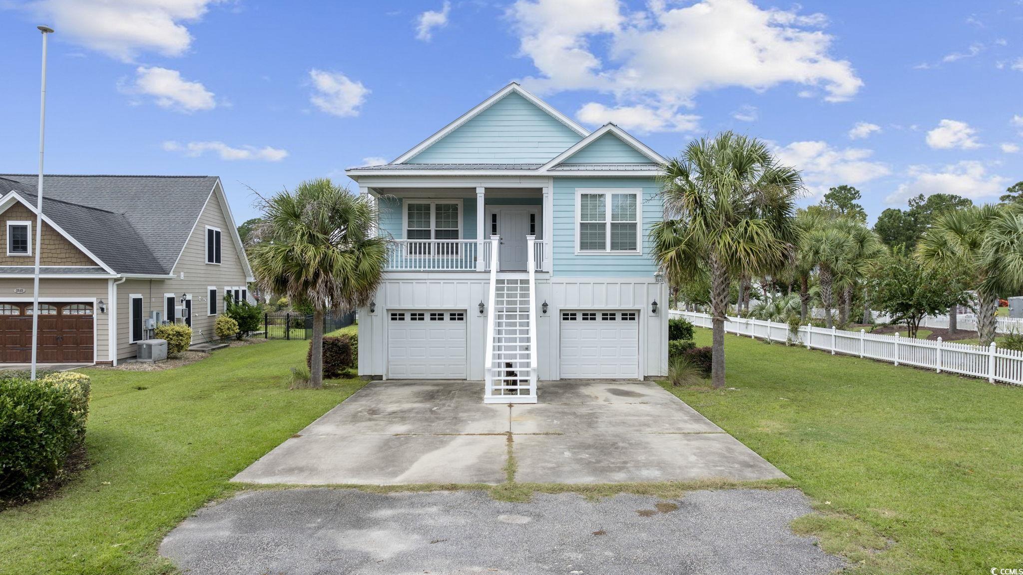 Coastal inspired home featuring a garage, covered