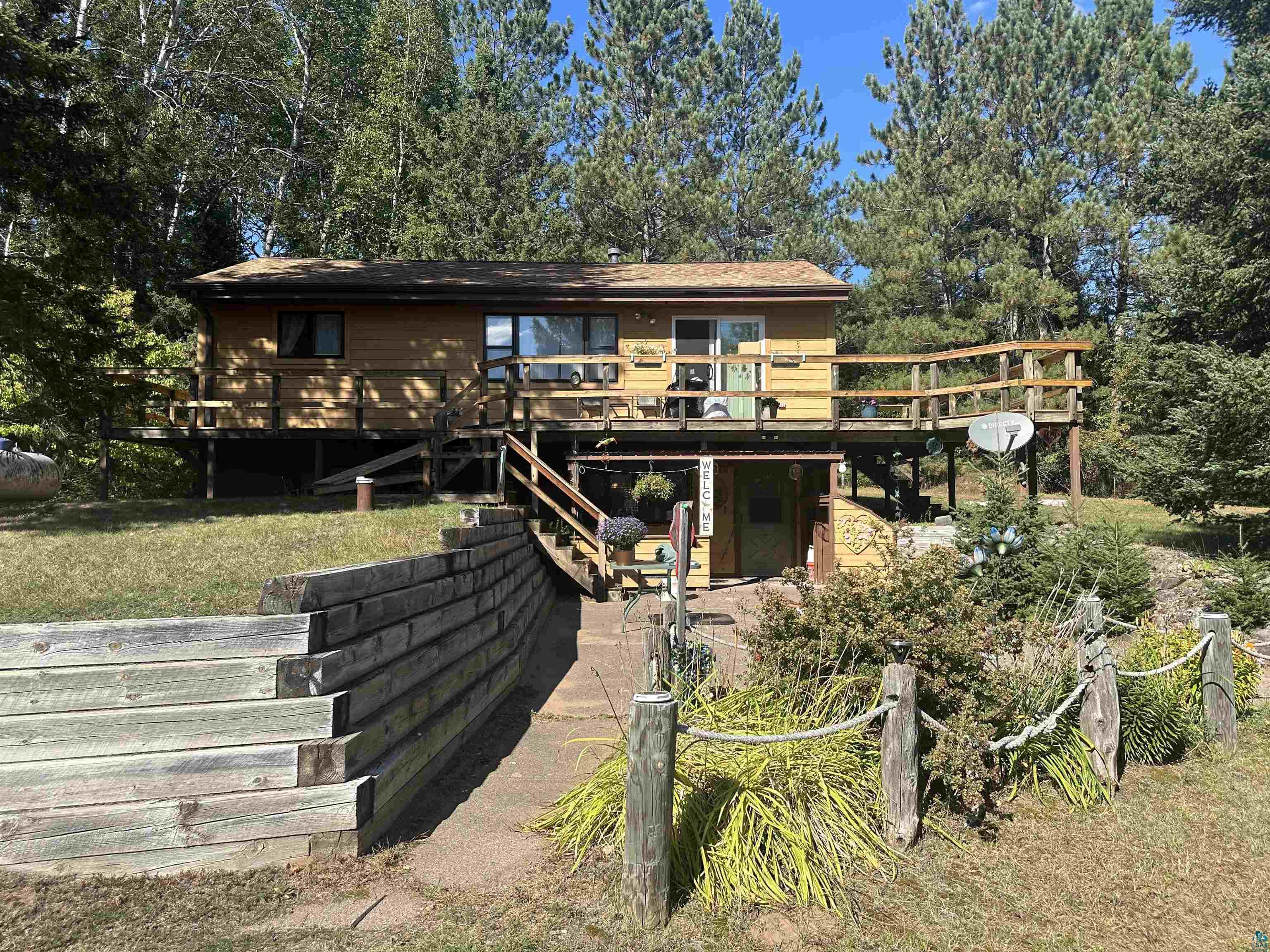 View of front facade with a wooden deck and a front yard