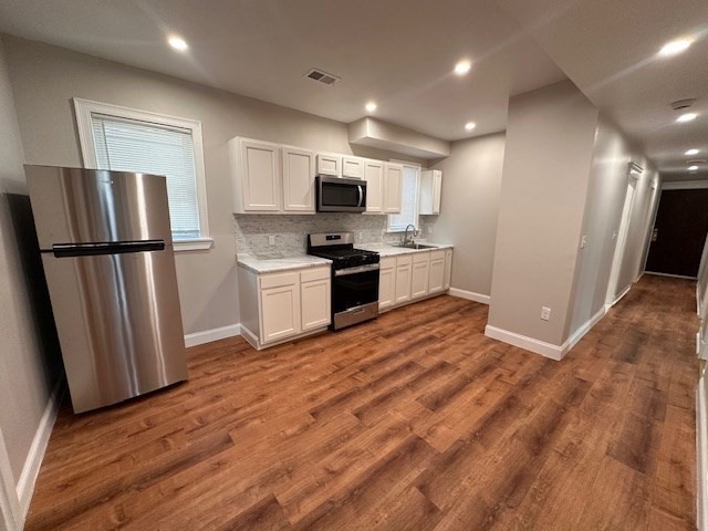 a kitchen with stainless steel appliances a refrigerator sink and microwave