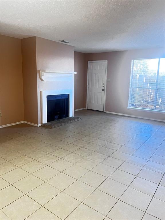 a view of an empty room with a fireplace and a window