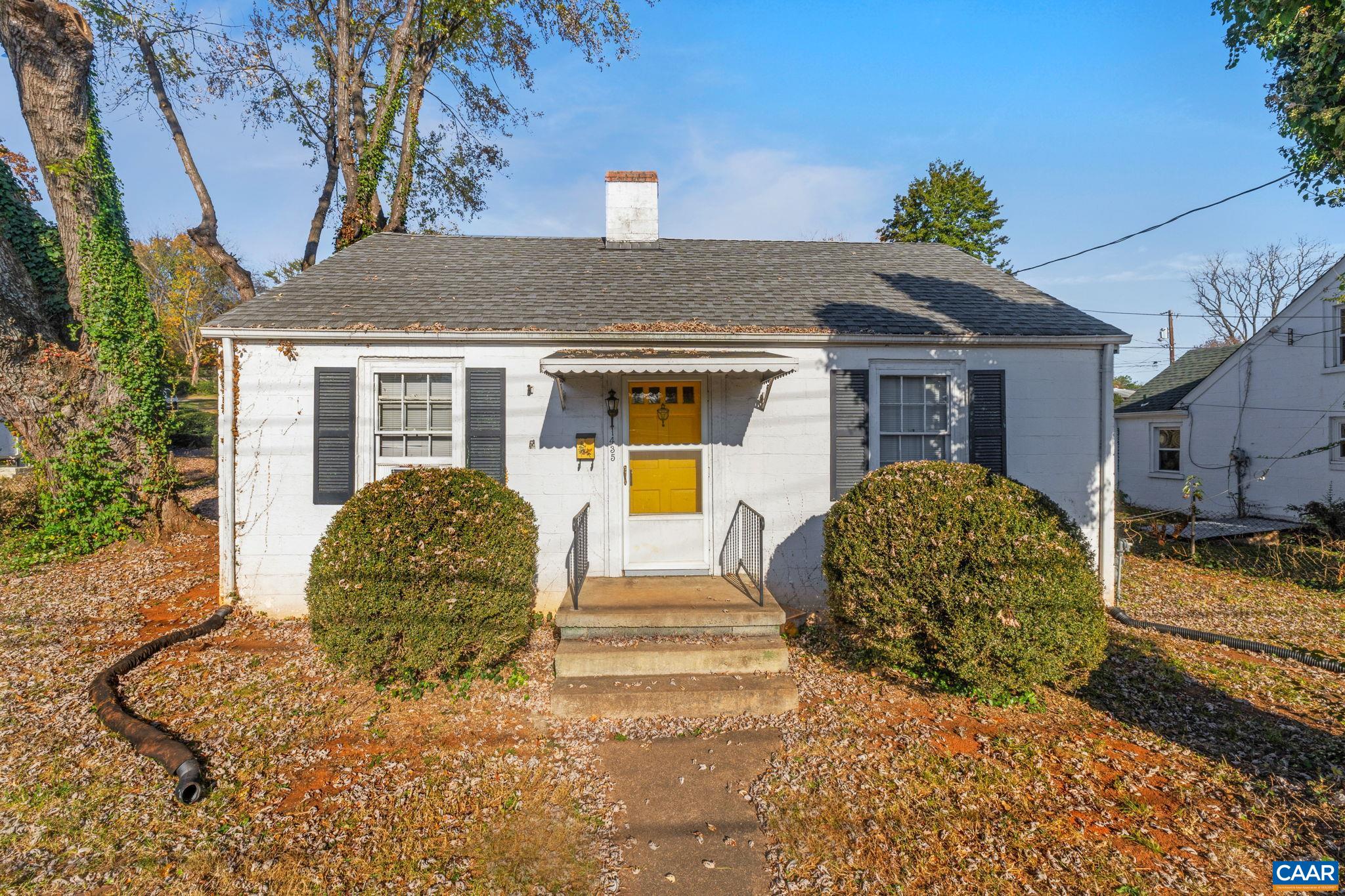 a view of a house with large windows and a tree