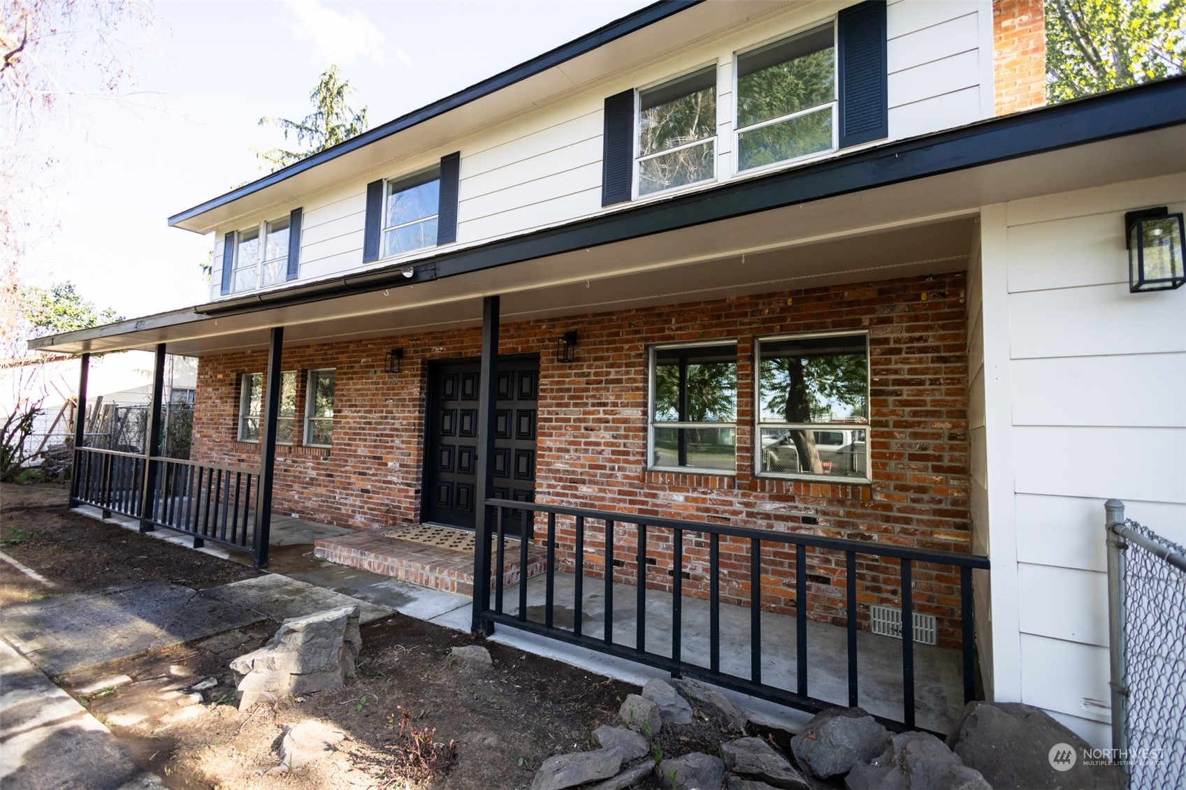 a view of a house with a large window and wooden fence