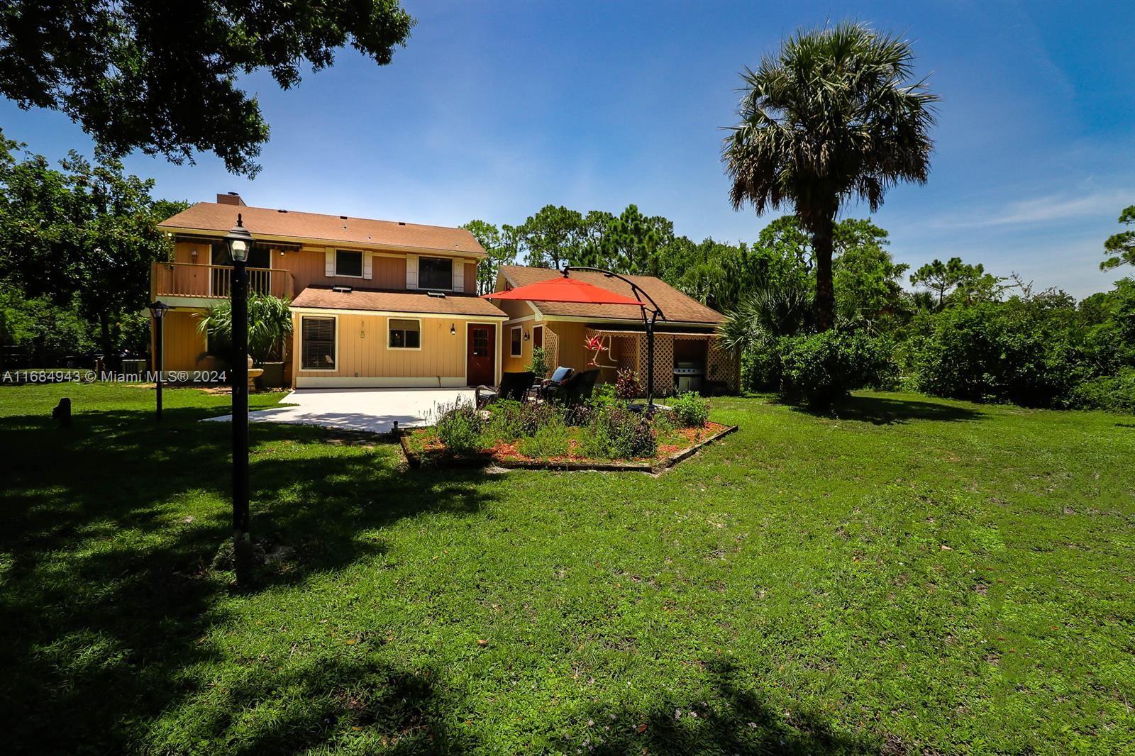 a front view of a house with garden and sitting area