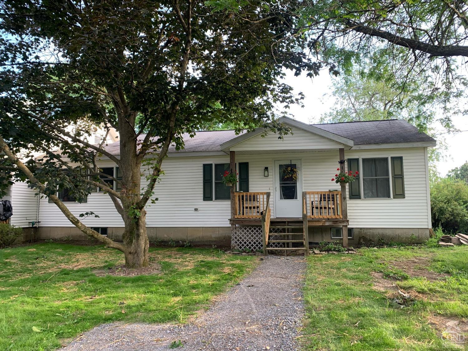 a view of a house with backyard and a tree