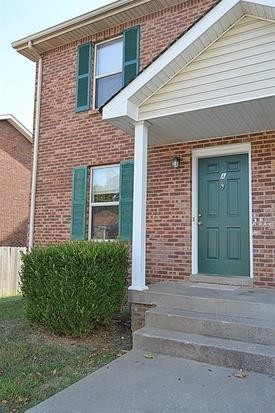 front view of a brick house with a small yard