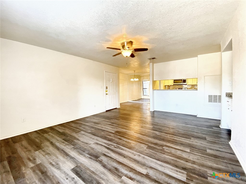 a view of a kitchen with wooden floor and a ceiling fan