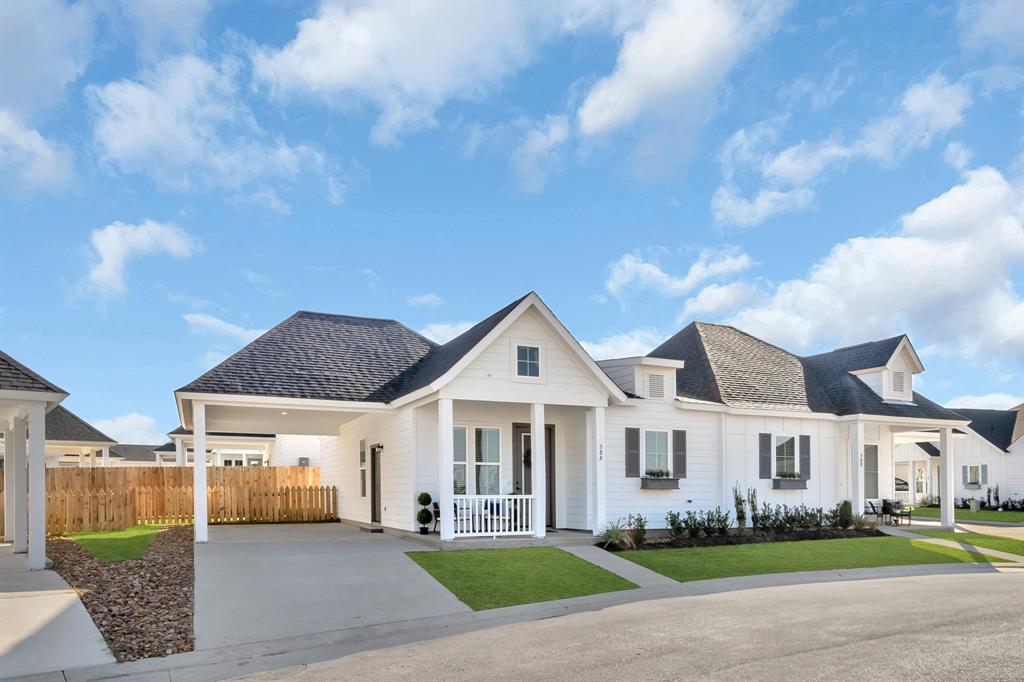 a front view of multiple houses with yard and green space