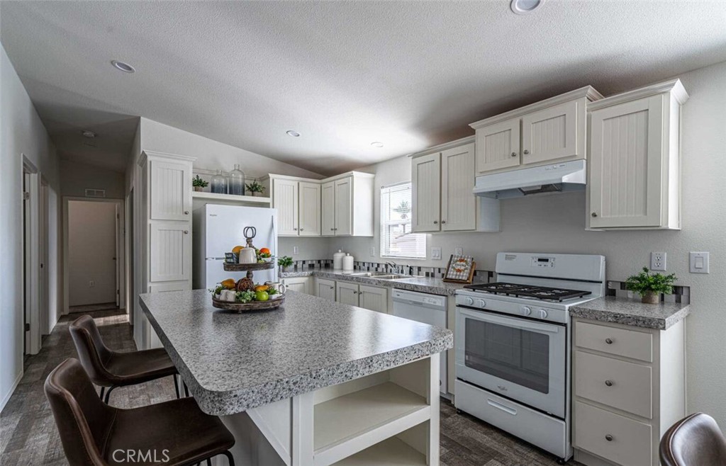 a kitchen with white cabinets and appliances