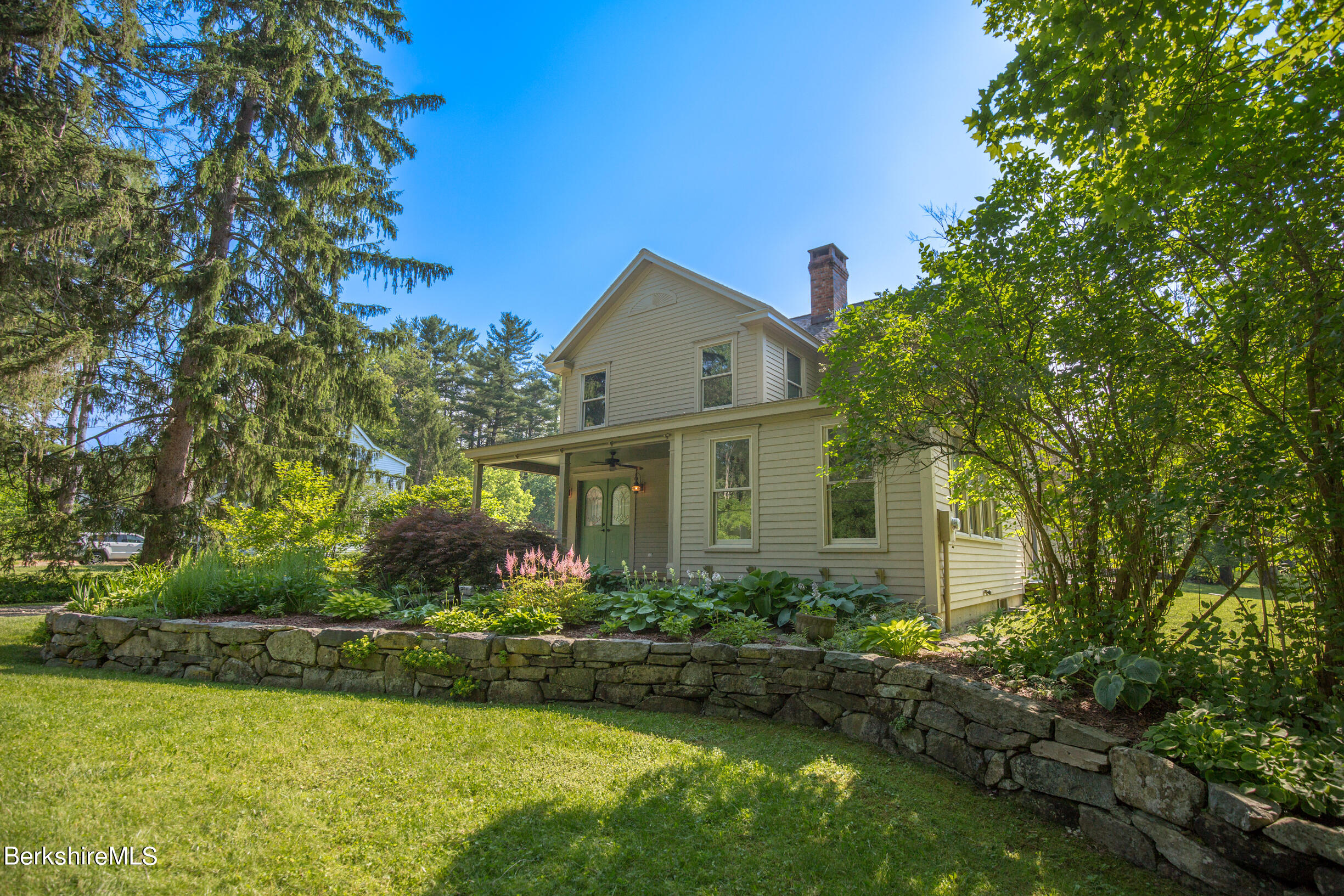 a front view of house with garden and trees