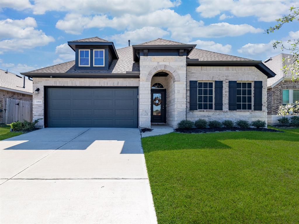 a front view of a house with a garden and yard