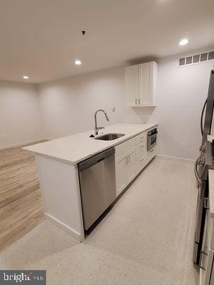 a kitchen with a sink appliances and cabinets