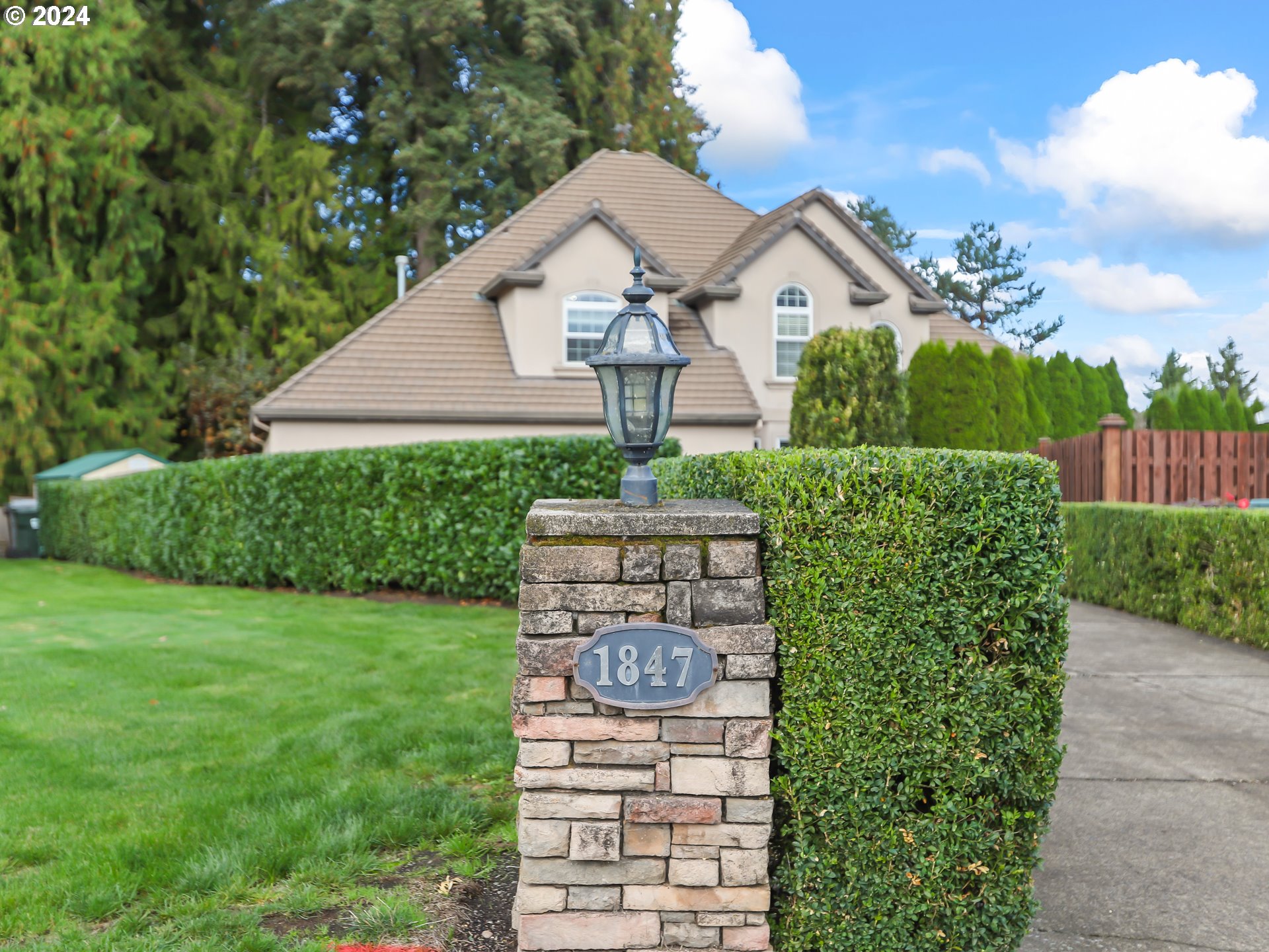 a front view of a house with a yard and fountain