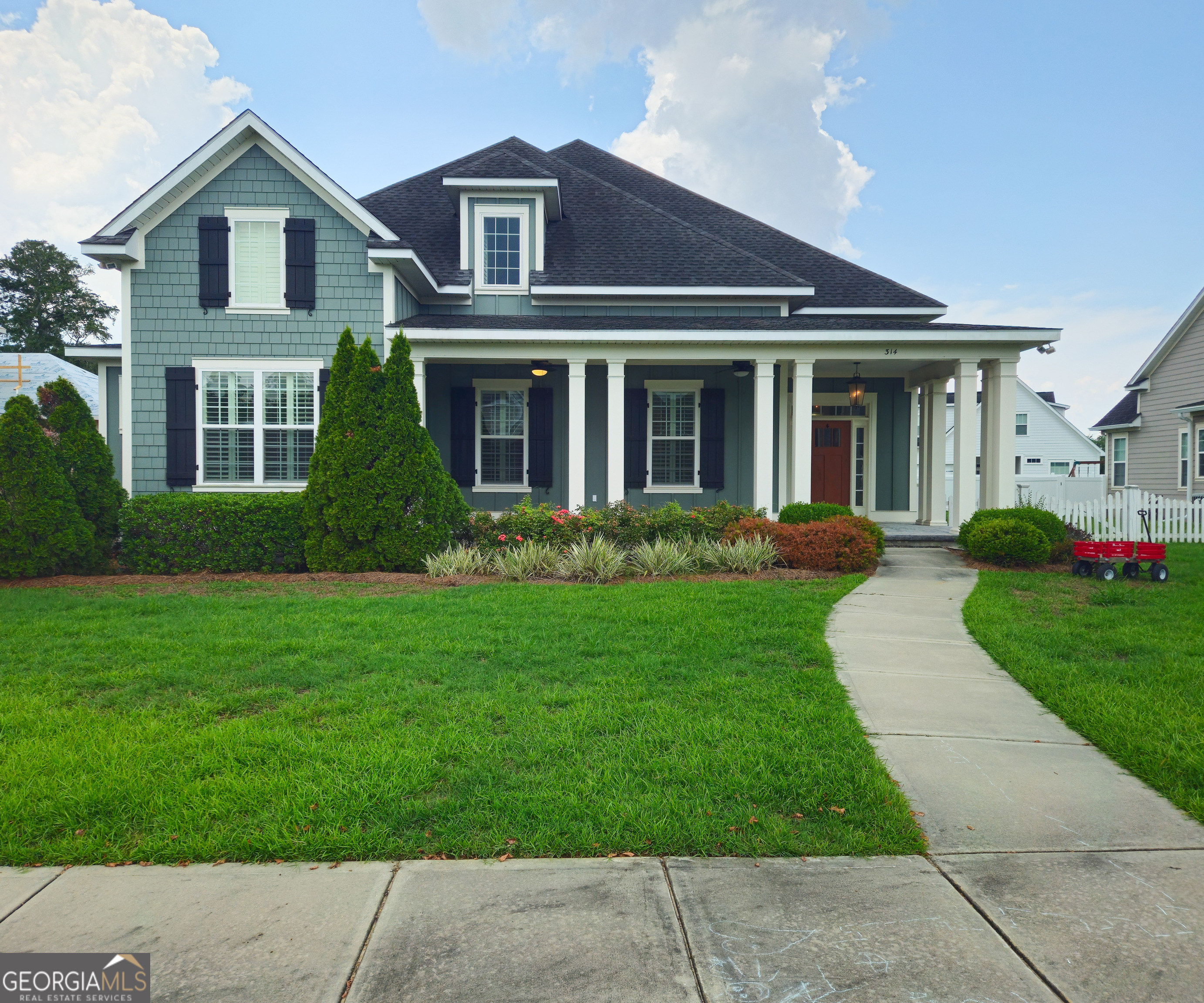 a front view of a house with a garden