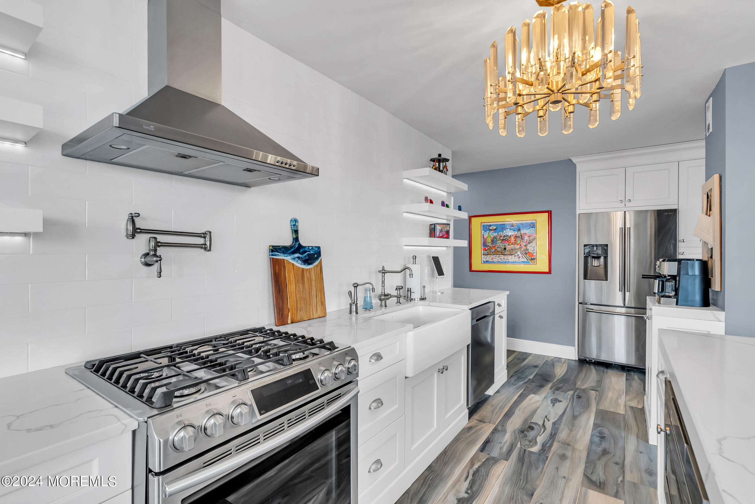 a kitchen with stainless steel appliances a stove a sink dishwasher and a refrigerator