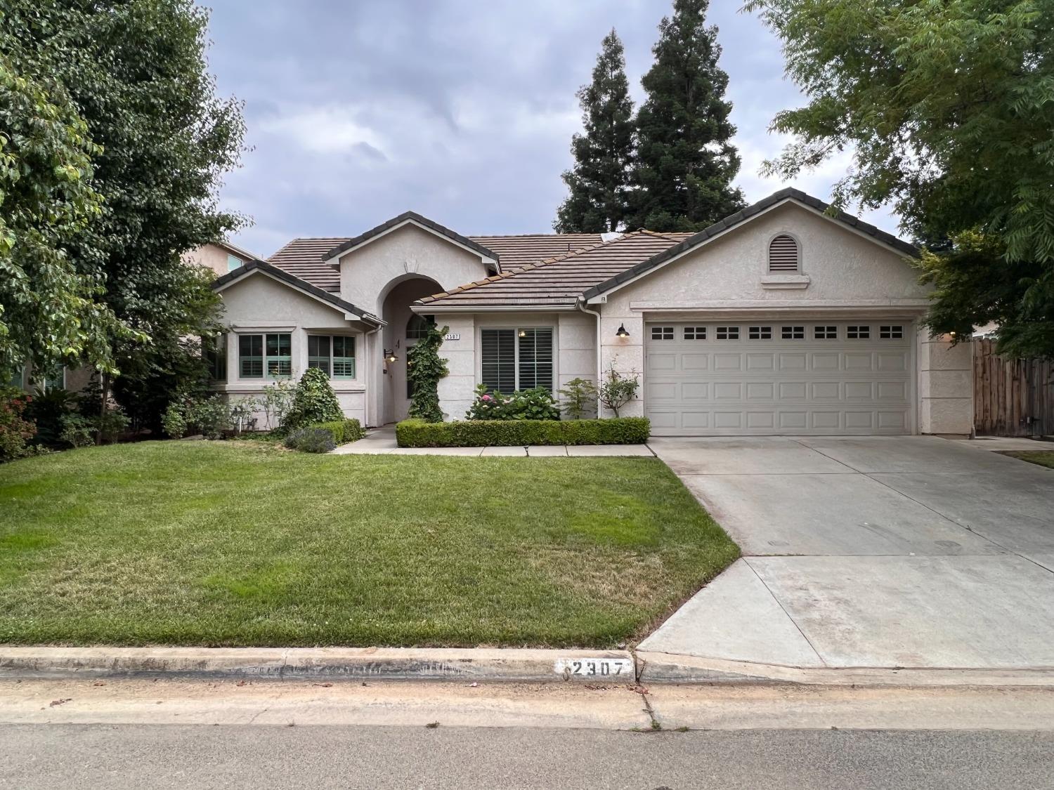 a front view of a house with a garden and plants