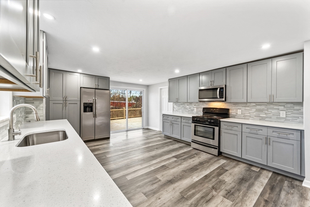 a kitchen with stainless steel appliances granite countertop a sink and a stove