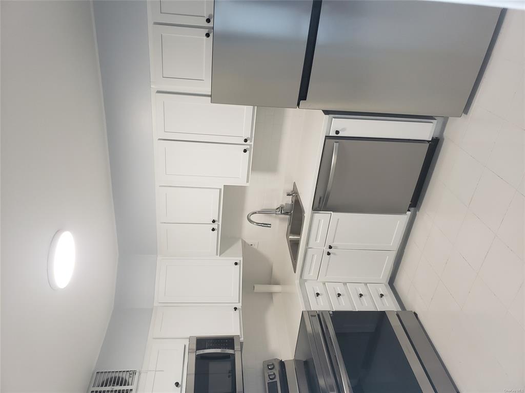 a kitchen with granite countertop white cabinets and white appliances