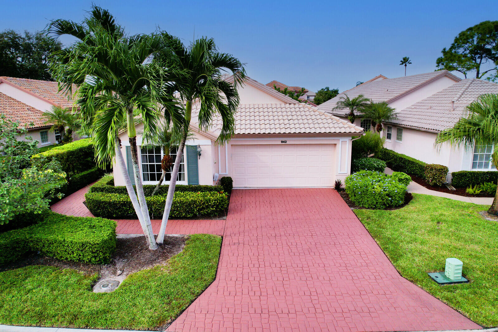 a front view of a house with yard and green space