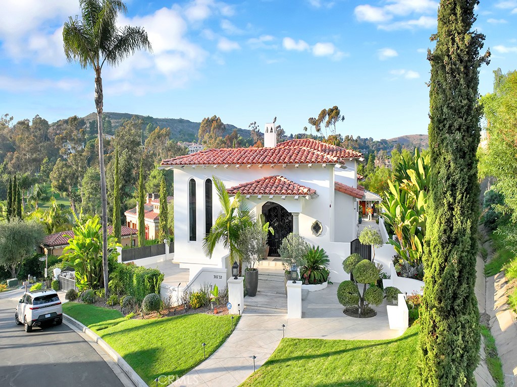 a front view of a house with a yard and potted plants