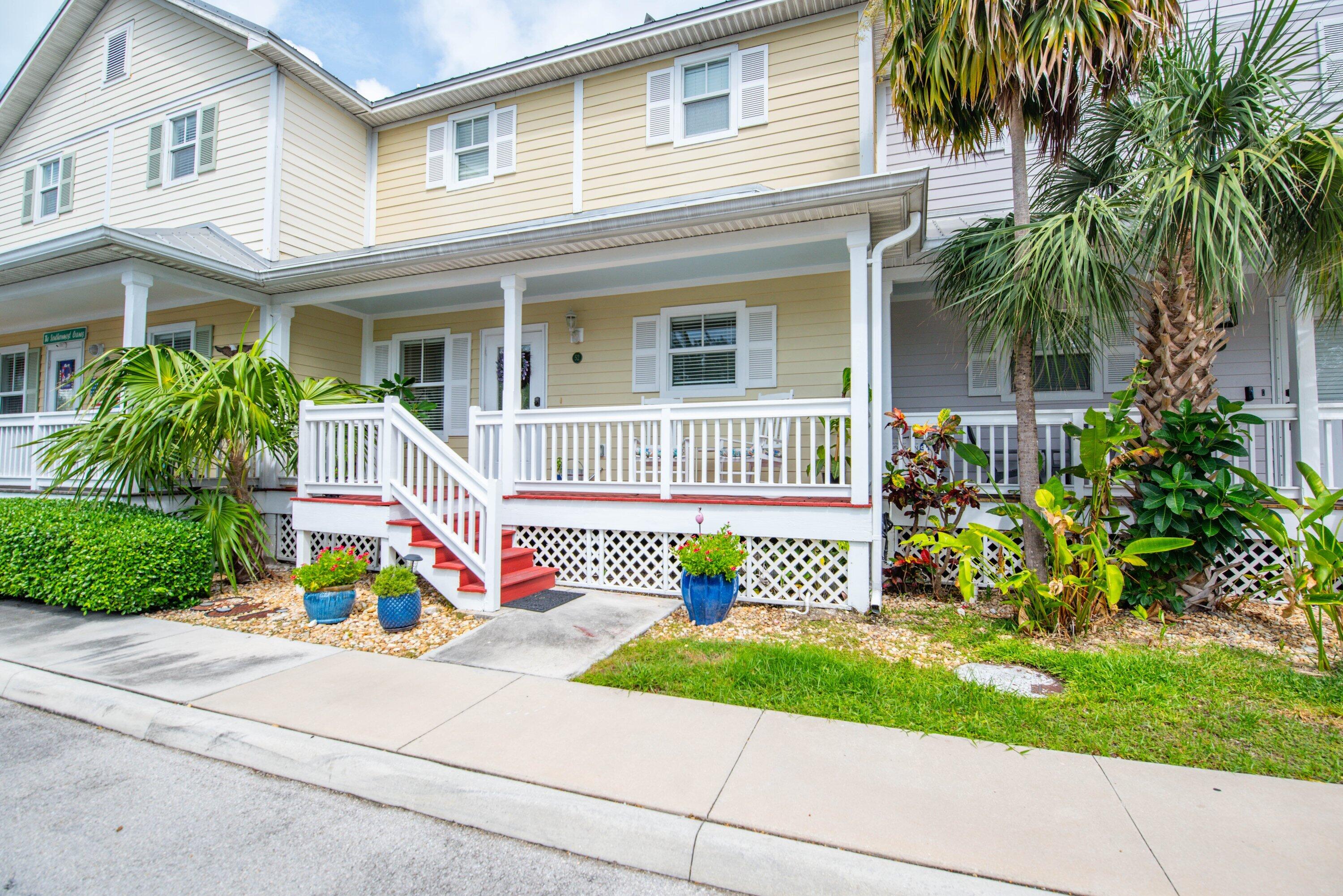 a front view of a house with a yard and potted plants