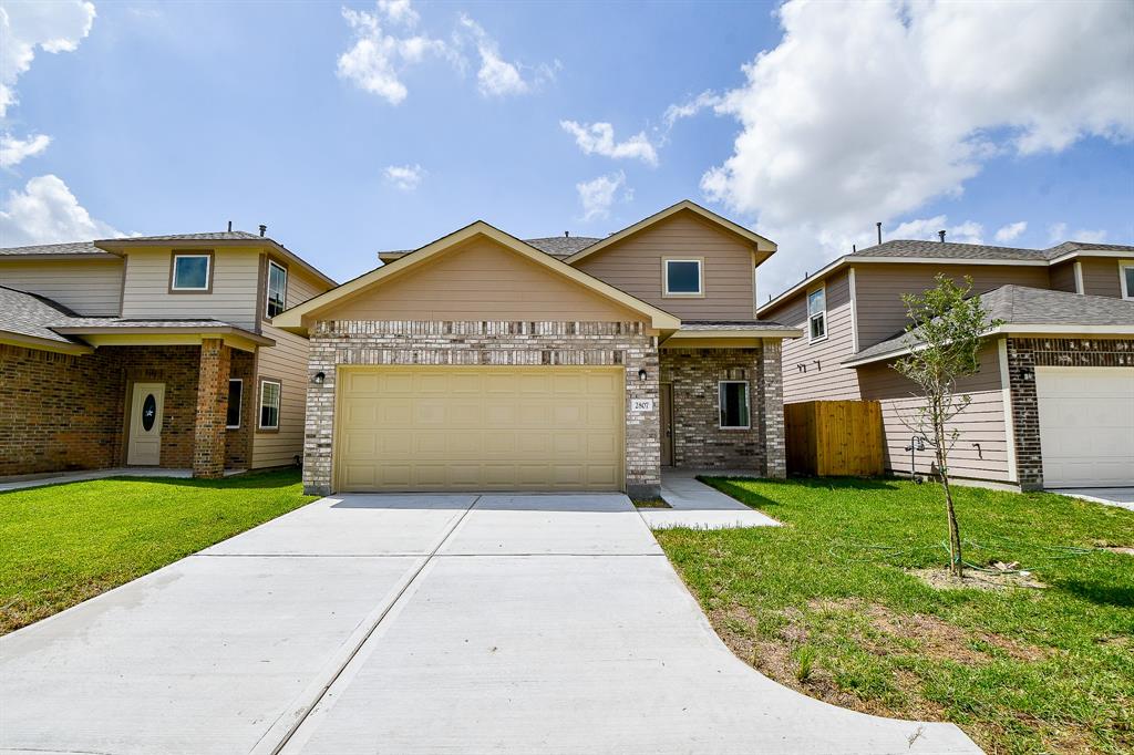 a front view of a house with a yard and garage