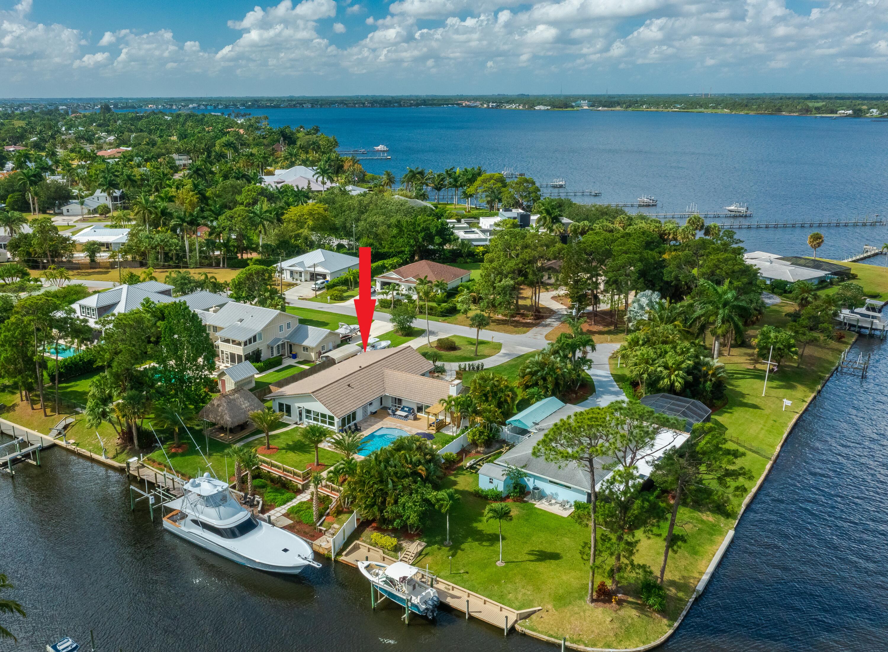 an aerial view of a house with a yard and lake view