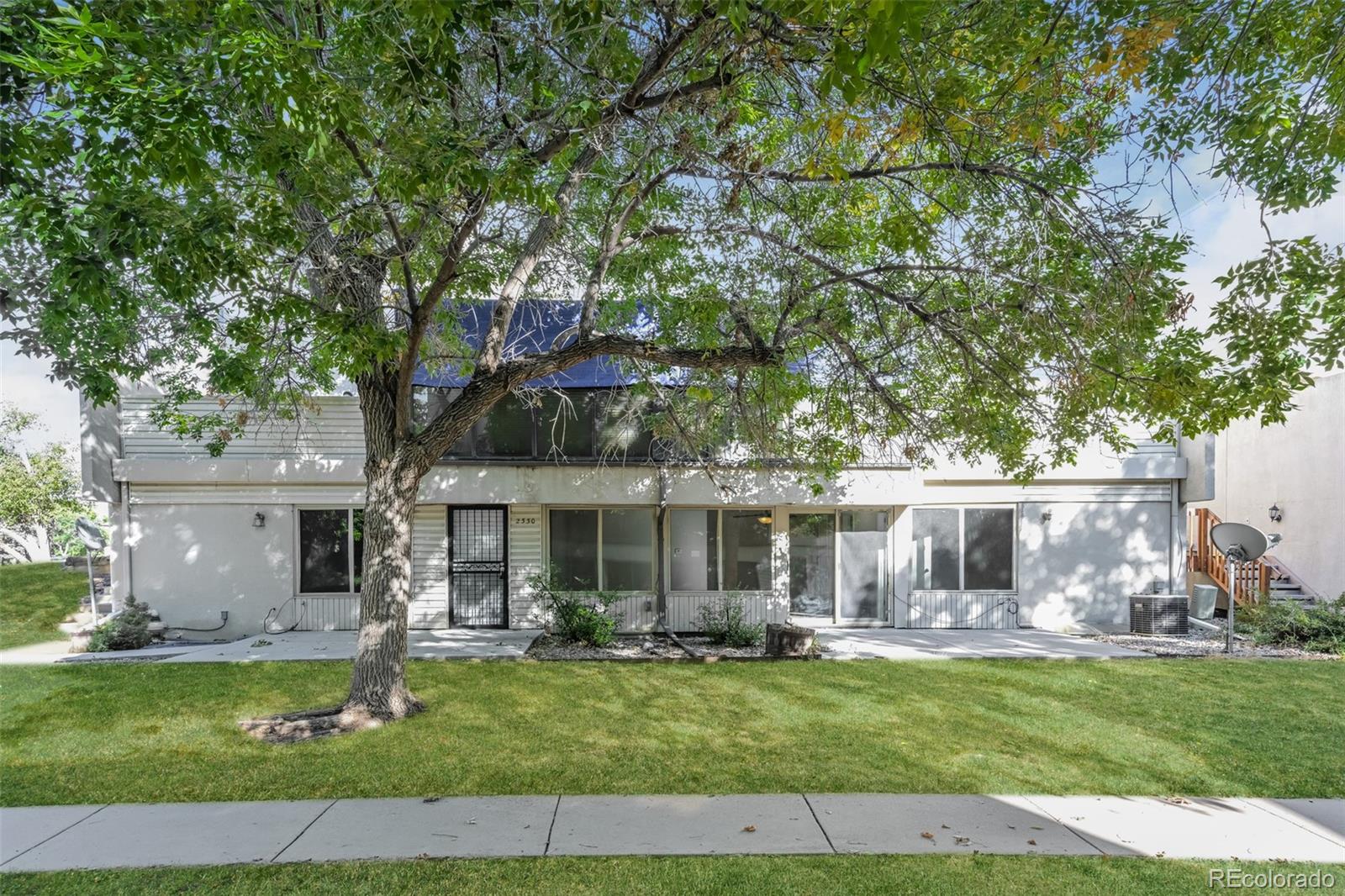 a front view of a house with a garden and patio