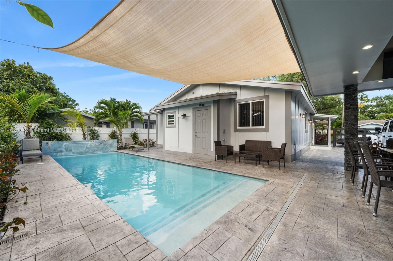 a view of a house with swimming pool and sitting area