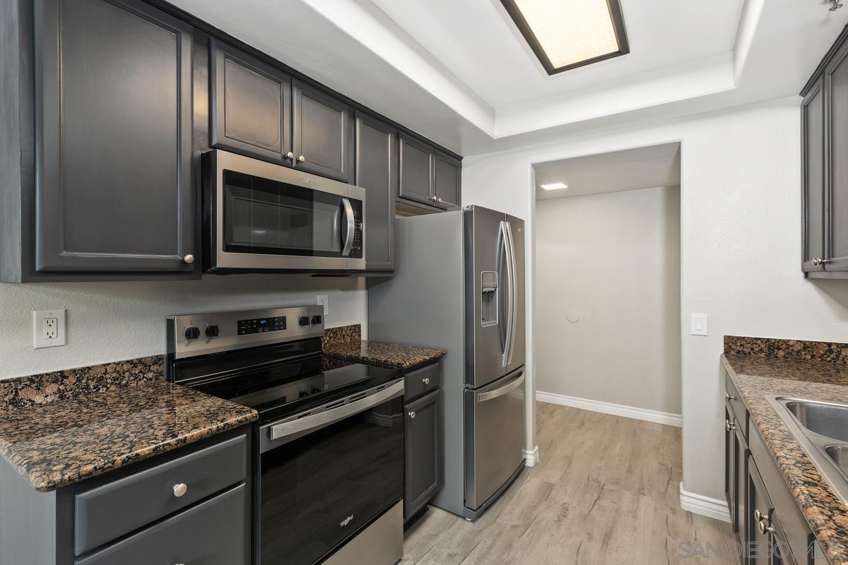 a kitchen with stainless steel appliances granite countertop a stove microwave and refrigerator