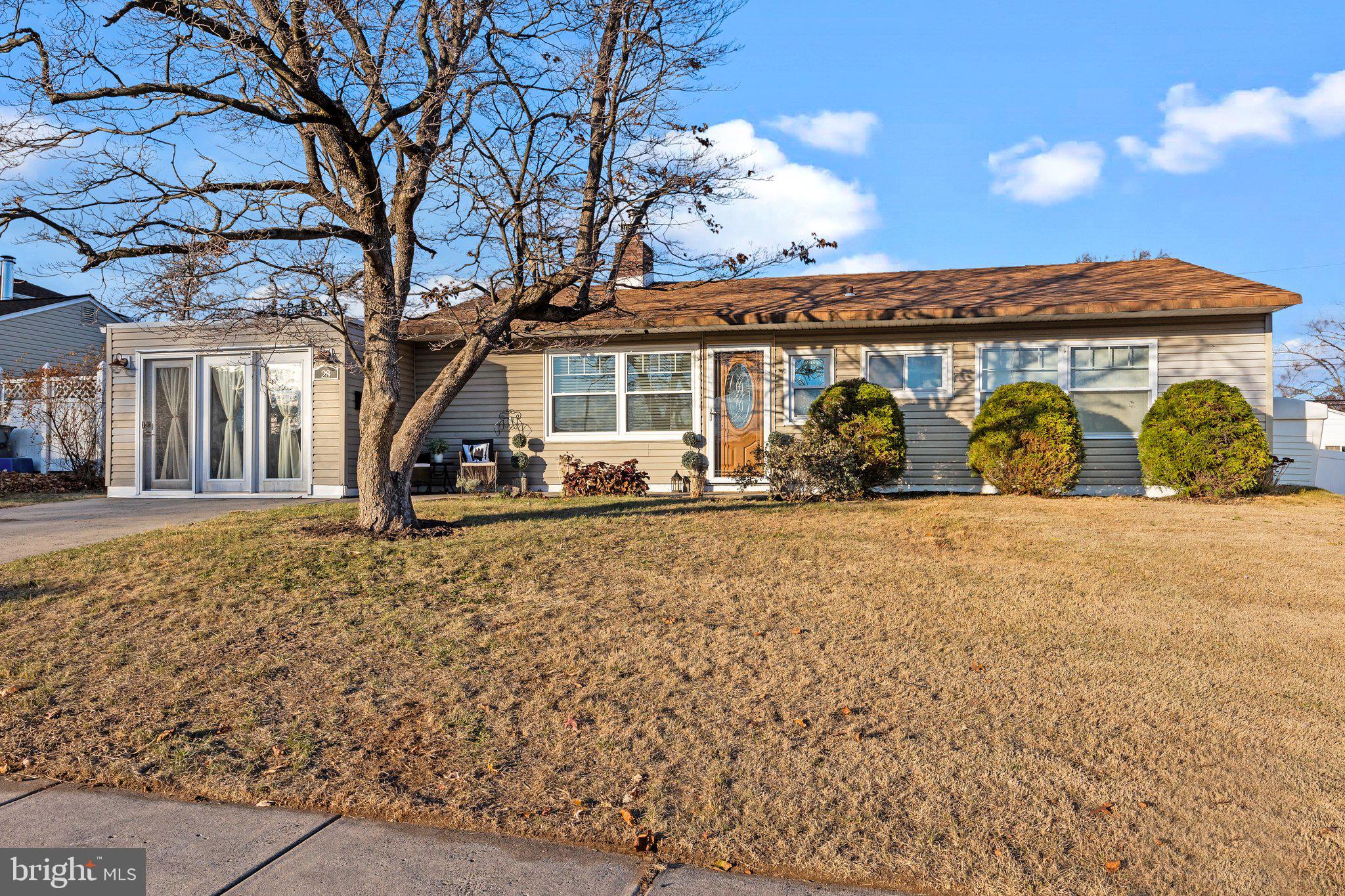 a front view of a house with large trees