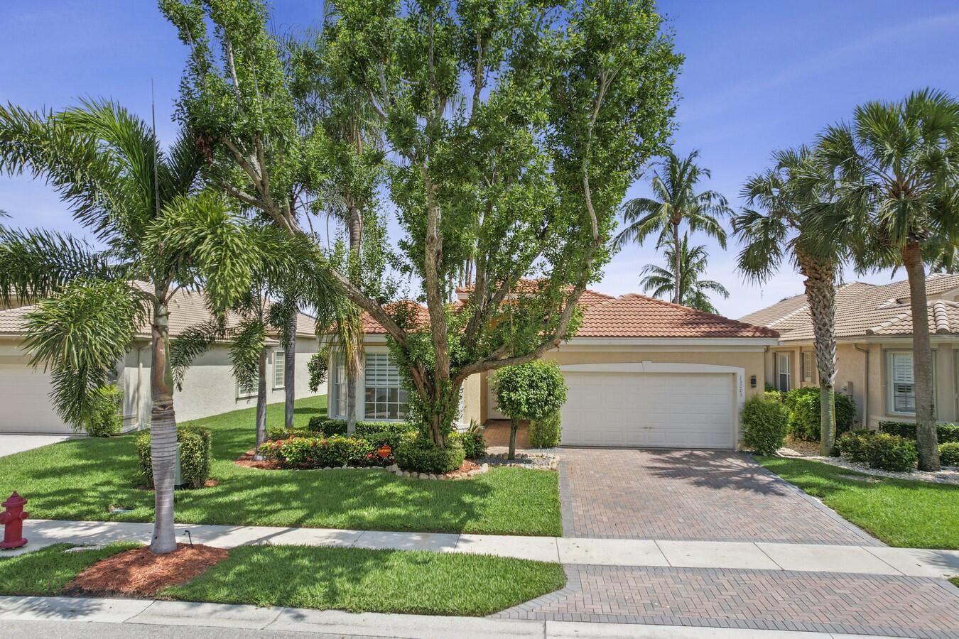 a front view of a house with a garden and trees