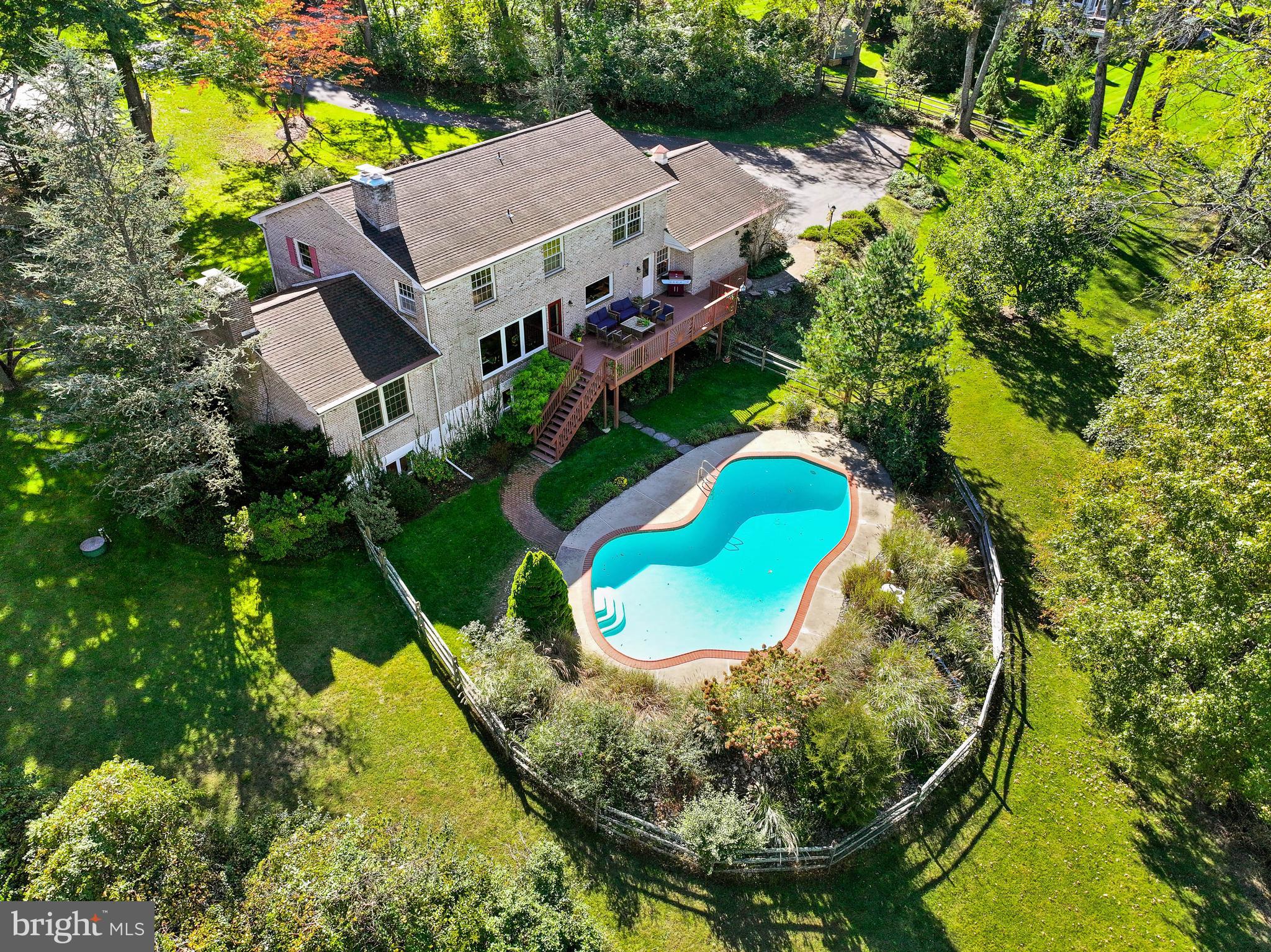 an aerial view of a house with a yard and large trees