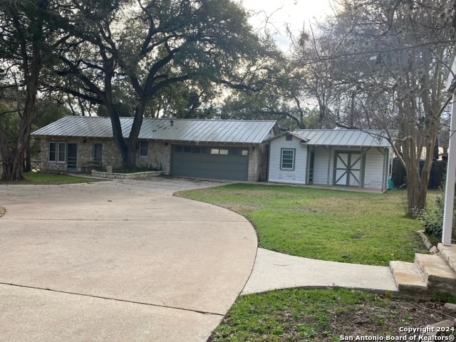 a front view of a house with a yard and trees