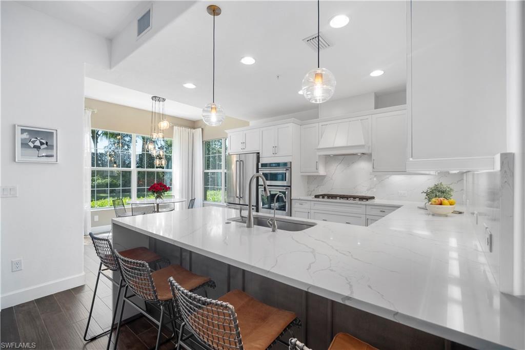 a kitchen with a dining table chairs sink and wooden floor