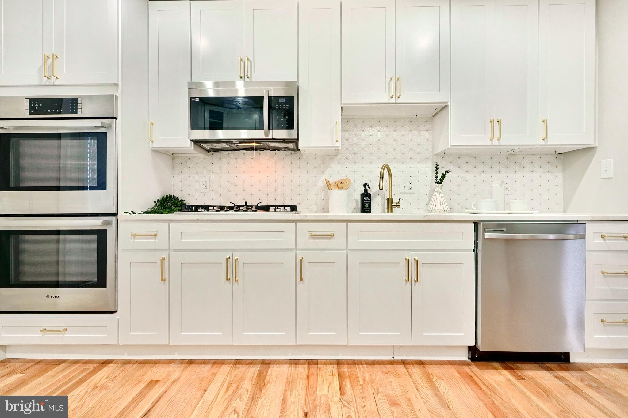 a kitchen with stainless steel appliances white cabinets and a sink