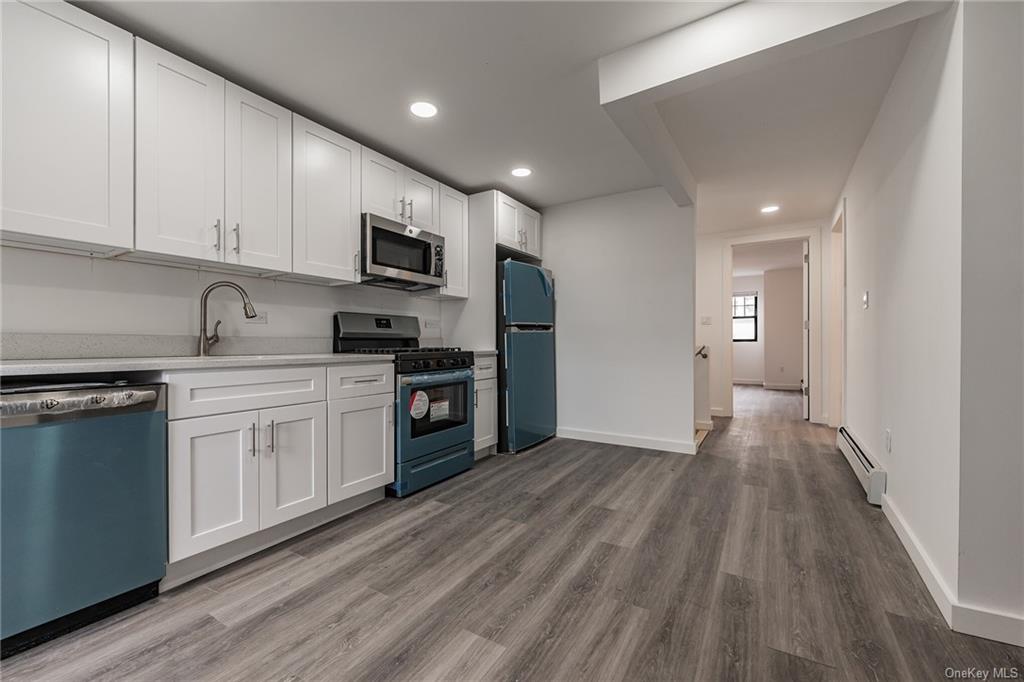 a kitchen with granite countertop a sink cabinets and stainless steel appliances