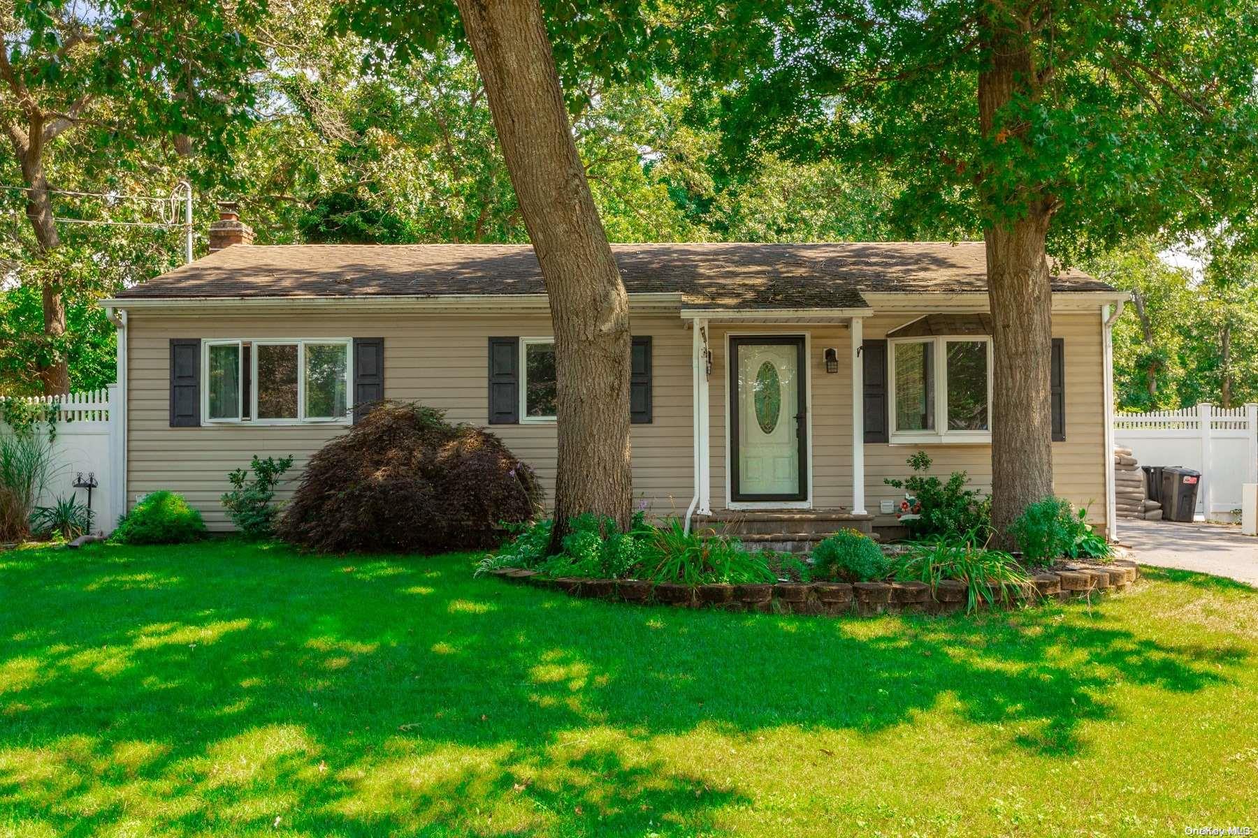 a view of a house with a yard and a large tree