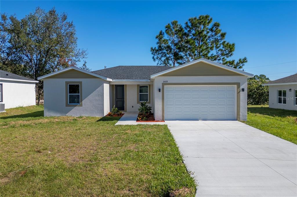 a front view of a house with a yard and garage