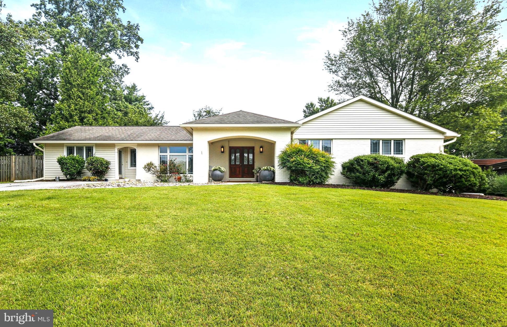 a front view of a house with yard and green space