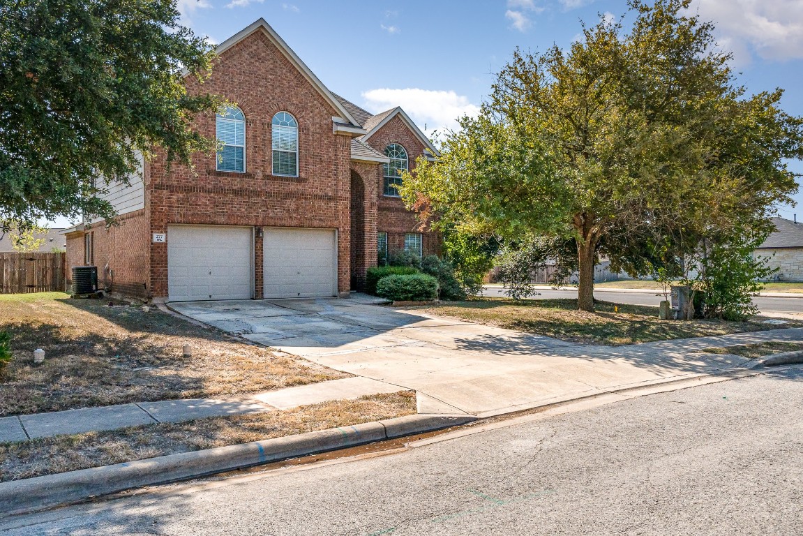 a view of a house with a yard and large tree