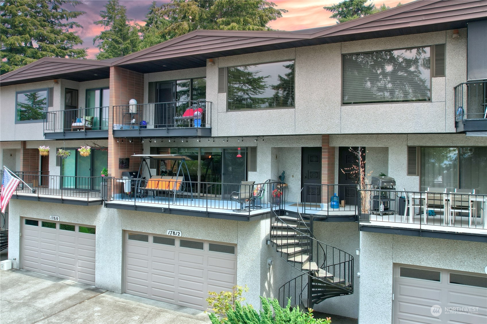 a front view of a multi story building with yard and outdoor seating