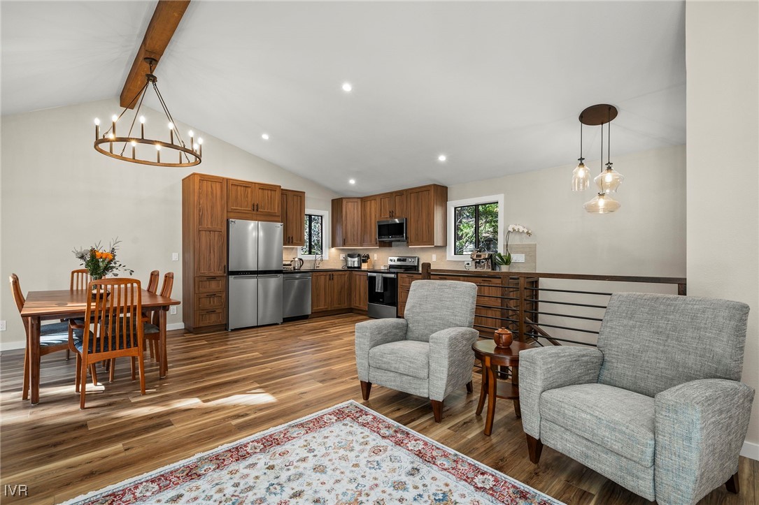 a living room with furniture kitchen view and a chandelier