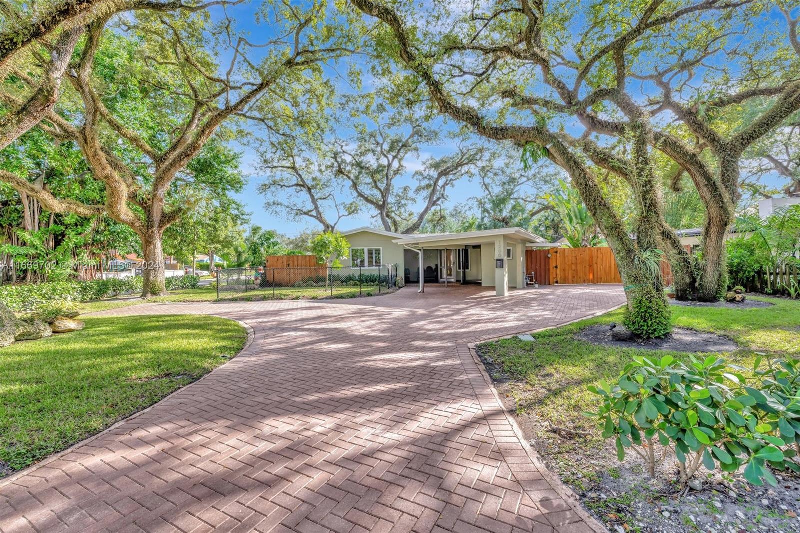 a front view of house with garden and trees