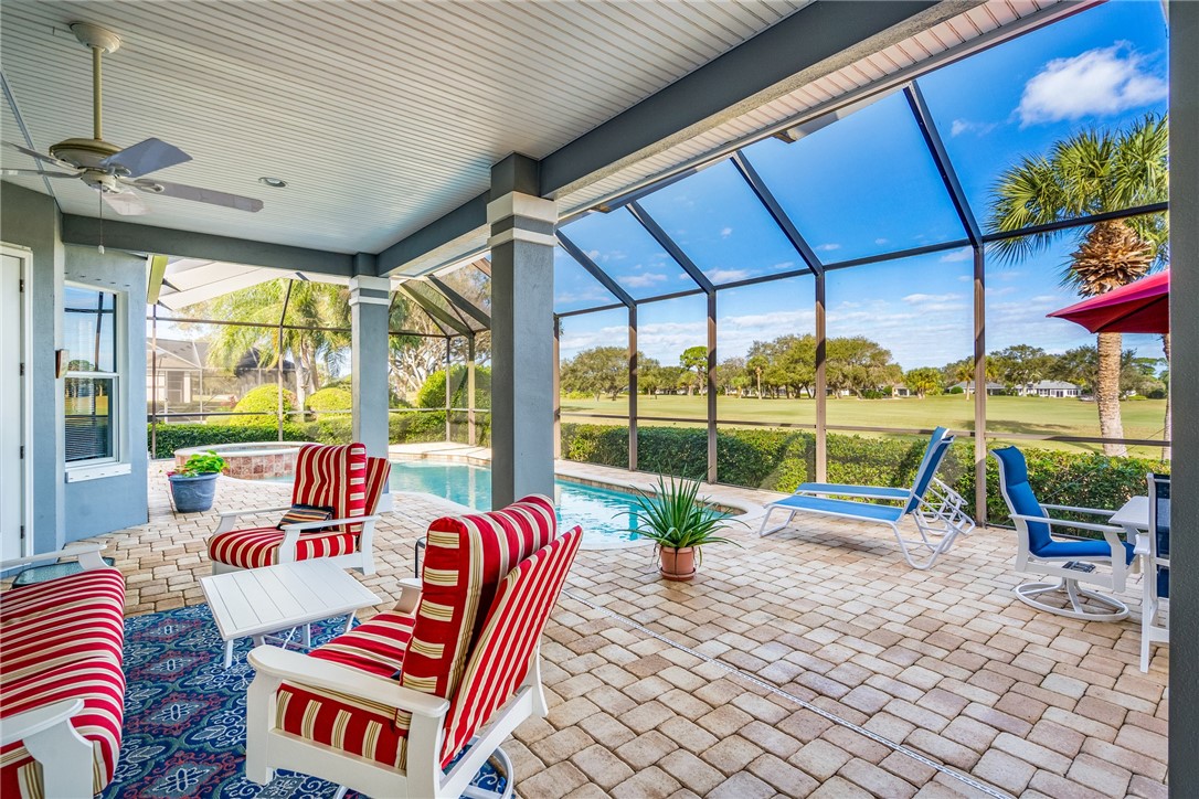 a living room with patio furniture and a floor to ceiling window