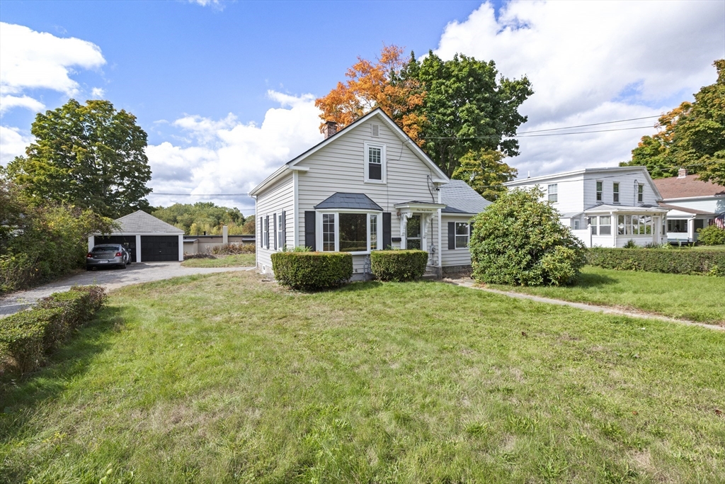 a front view of a house with a yard and trees