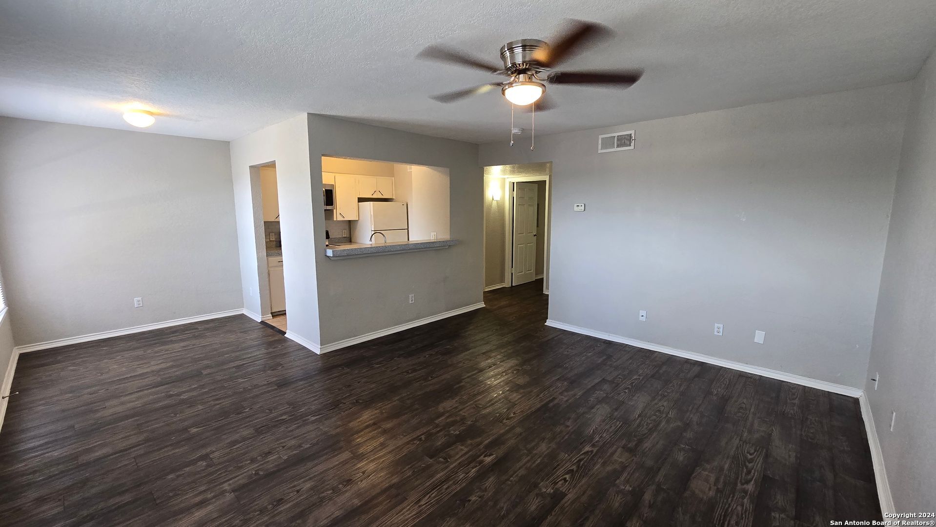 an empty room with wooden floor and window