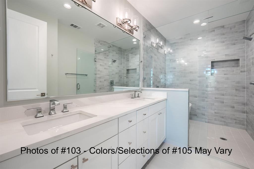 a bathroom with a sink double vanity granite tub shower and a mirror